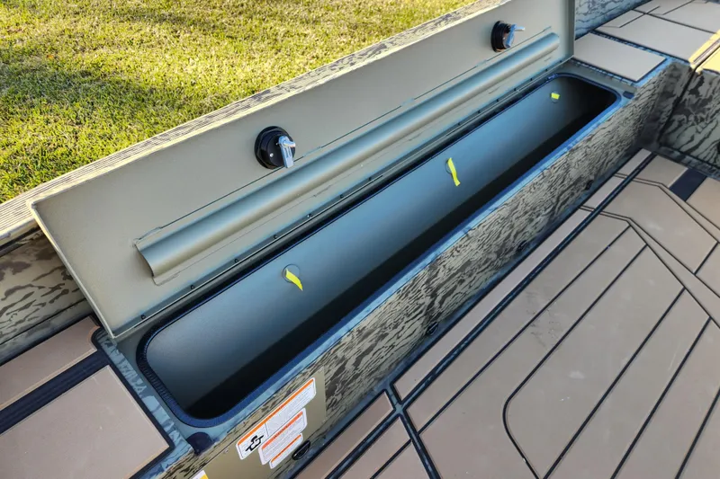 Slide: The Image of 2026 Tracker Grizzly 1756 T Marsh boat storage compartment, open and empty, on a sunny day. - 10