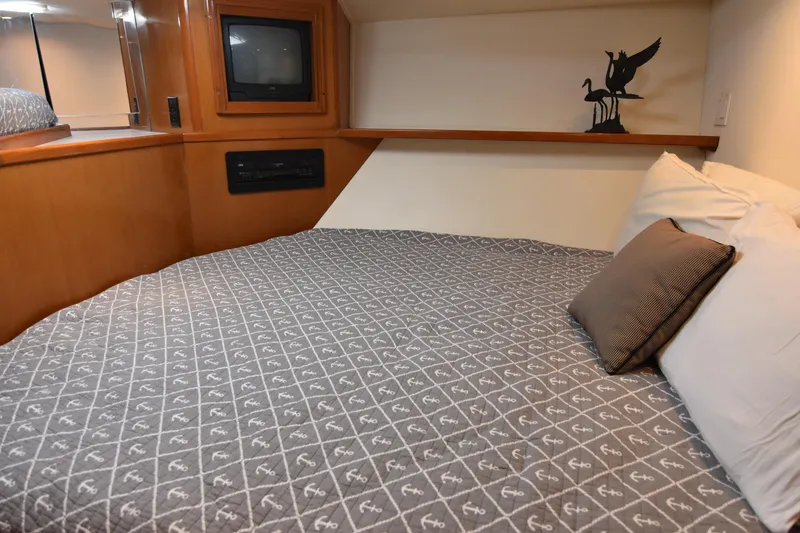 Slide: The Image of Cozy bedroom in 1999 Viking 58 Convertible yacht with TV and decorative sculpture. - 27