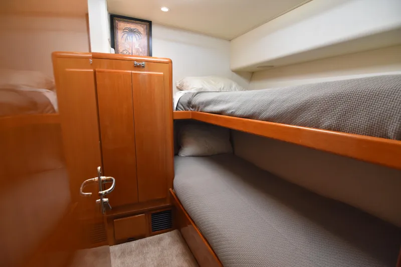 Slide: The Image of 1999 Viking 58 Convertible yacht interior with wooden bunk beds and cozy bedding. - 29