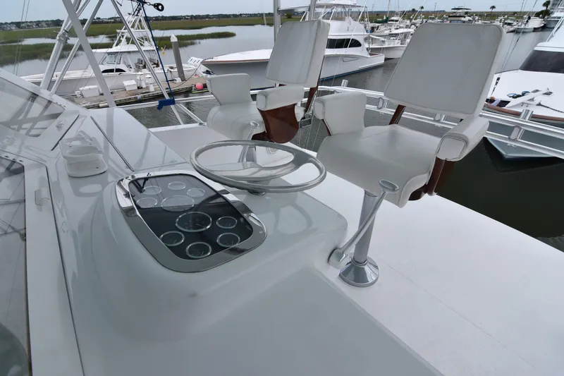 Slide: The Image of 1999 Viking 58 Convertible yacht helm with white captain chairs and control panel. - 33