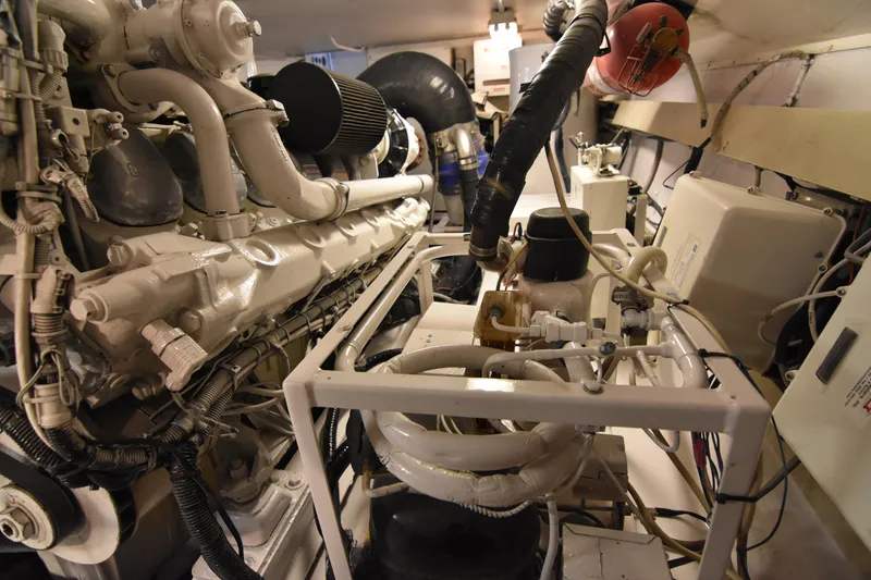Slide: The Image of Engine room of a 1999 Viking 58 Convertible yacht, showcasing complex machinery and components. - 43