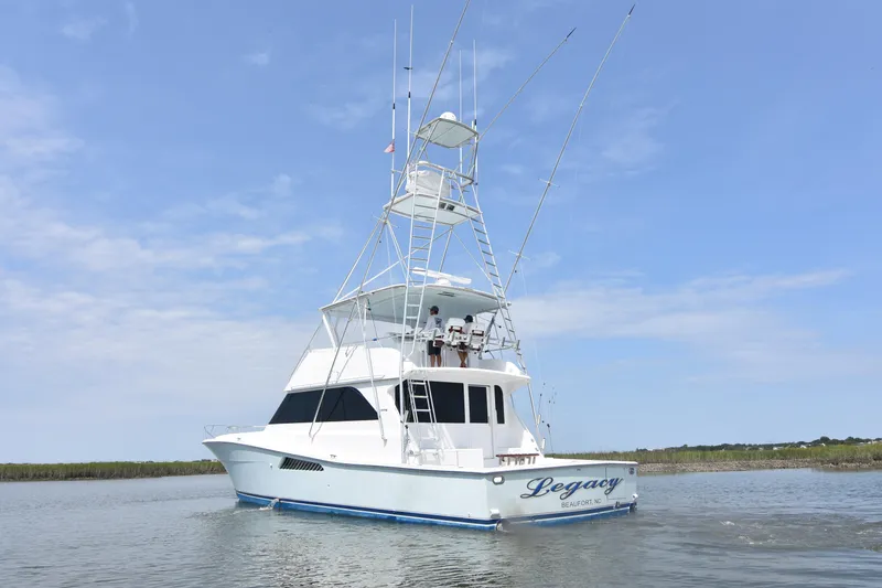 Slide: The Image of 1999 Viking 58 Convertible yacht on calm water under clear blue sky. - 45