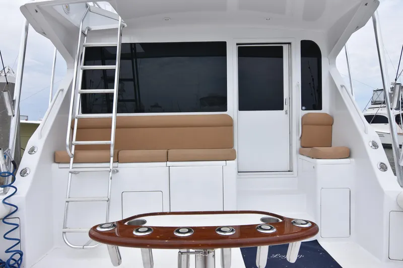 Slide: The Image of 1999 Viking 58 Convertible yacht cockpit with ladder, seating, and fishing rod holders. - 8