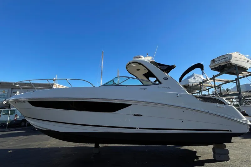 Slide: The Image of 2016 Sea Ray 310 Sundancer boat on display under clear blue sky. - 1