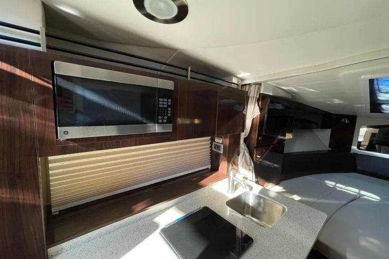 Slide: The Image of Interior of 2016 Sea Ray 310 Sundancer with modern kitchen and seating area. - 14