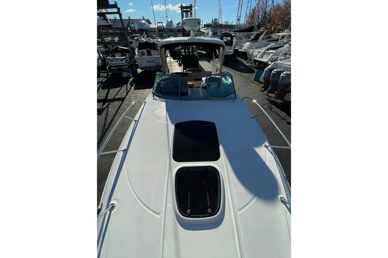 Slide: The Image of 2016 Sea Ray 310 Sundancer yacht docked in a marina, surrounded by other boats. - 15