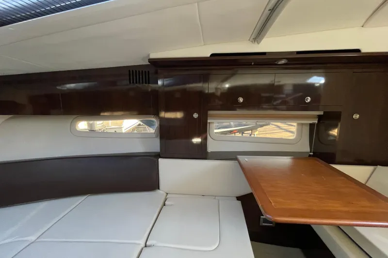 Slide: The Image of 2016 Sea Ray 310 Sundancer cabin interior with wood table and seating area. - 4