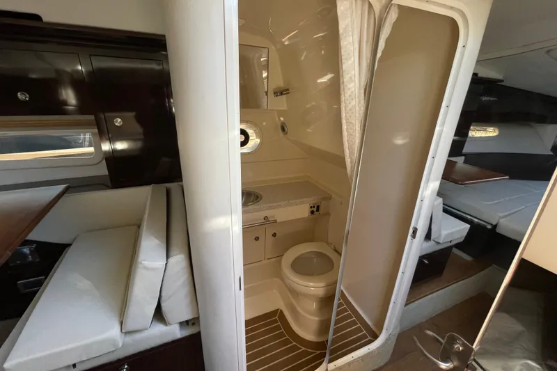 Slide: The Image of Interior of 2016 Sea Ray 310 Sundancer showing compact bathroom and seating area. - 6