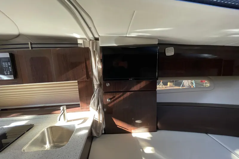 Slide: The Image of Interior of 2016 Sea Ray 310 Sundancer yacht with modern kitchen and TV. - 8