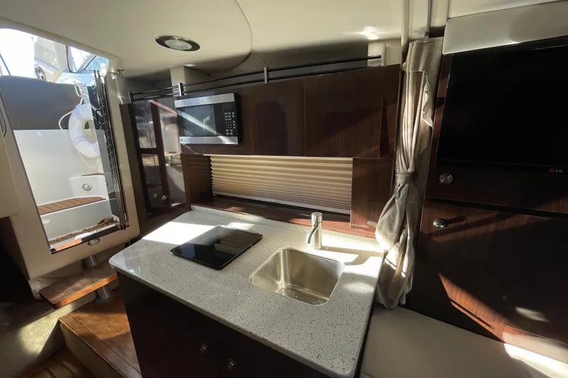 Slide: The Image of Interior of 2016 Sea Ray 310 Sundancer yacht with modern kitchen amenities. - 9