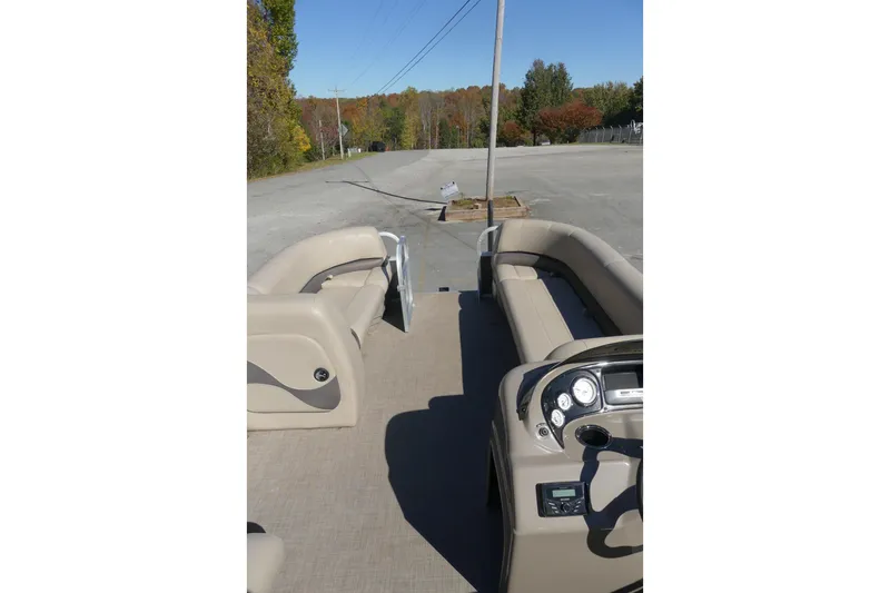 Slide: The Image of 2023 Sun Tracker Party Barge 18 DLX interior with beige seating and control panel. - 5