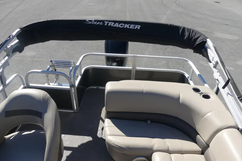 Slide: The Image of 2023 Sun Tracker Party Barge 18 DLX interior with beige seating and cup holders. - 6