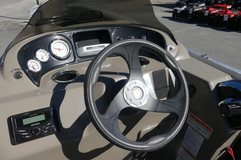 Slide: The Image of 2023 Sun Tracker Party Barge 18 DLX dashboard with steering wheel and gauges. - 7