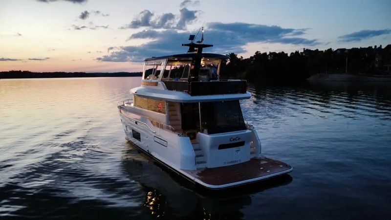 Slide: The Image of Luxury 2021 Sirena 58 yacht cruising at sunset on a serene lake. - 10