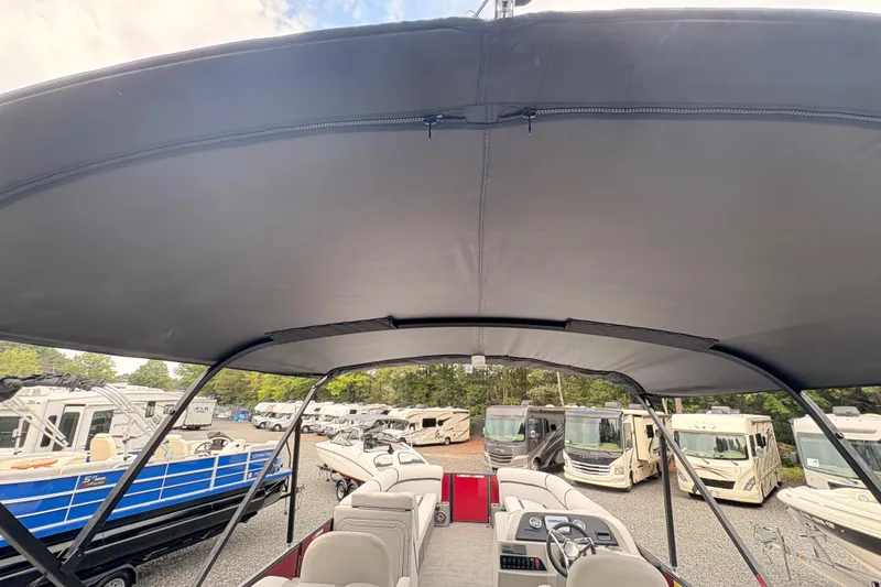 Slide: The Image of 2023 Crest Classic LX 220 SLRC boat with canopy, surrounded by RVs and boats. - 15