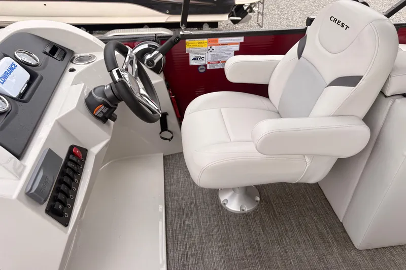 Slide: The Image of 2023 Crest Classic LX 220 SLRC boat helm with white captain's chair and steering wheel. - 17
