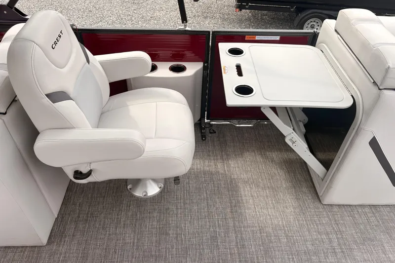Slide: The Image of 2023 Crest Classic LX 220 SLRC boat interior with white captain's chair and foldable table. - 19