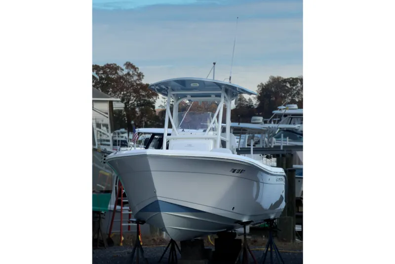 Slide: The Image of 2020 Cobia 220 Center Console boat on stands, marina background. - 11