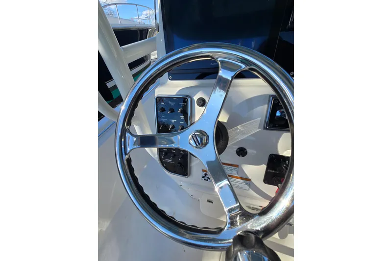 Slide: The Image of Steering wheel of a 2020 Cobia 220 Center Console boat, showcasing controls. - 16