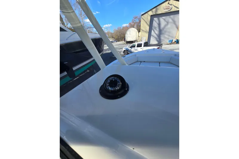 Slide: The Image of 2020 Cobia 220 Center Console boat with compass, parked near marina. - 19