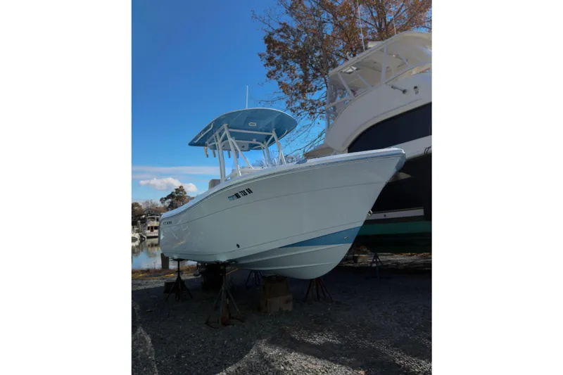 Slide: The Image of 2020 Cobia 220 Center Console boat seat, featuring gray cushioned design and armrests. - 2