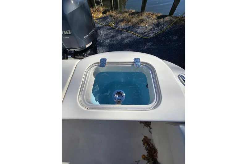 Slide: The Image of 2020 Cobia 220 Center Console livewell with Yamaha outboard motor in background. - 22