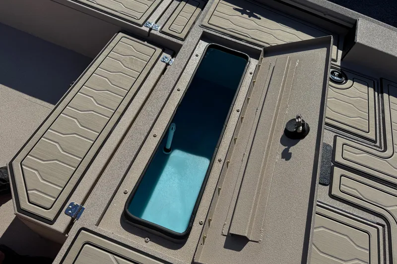 Slide: The Image of Open storage compartment on 2026 Avid 18 Commander boat, featuring textured panels and secure latch. - 13
