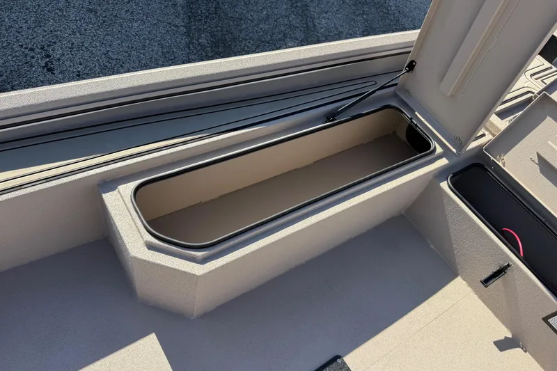 Slide: The Image of 2026 Avid 18 Commander boat storage compartment, open lid, interior view. - 14