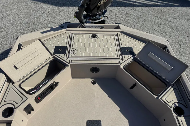 Slide: The Image of 2026 Avid 18 Commander boat deck with open storage compartments and textured flooring. - 17