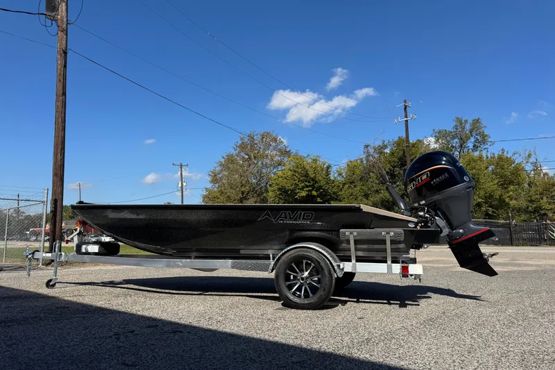 Slide: The Image of 2026 Avid 18 Commander boat on trailer with Yamaha outboard motor, parked outdoors. - 7