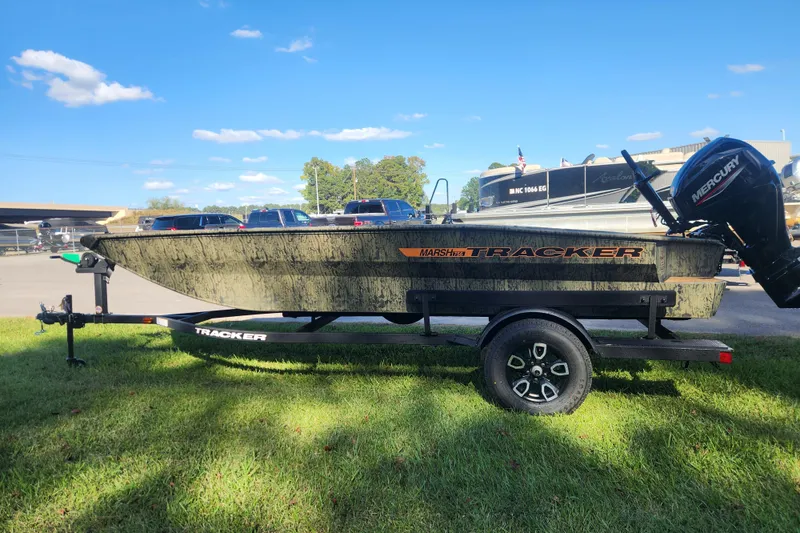 Slide: The Image of 2026 Tracker Grizzly 1756 T Marsh boat on trailer, parked on grass under blue sky. - 5