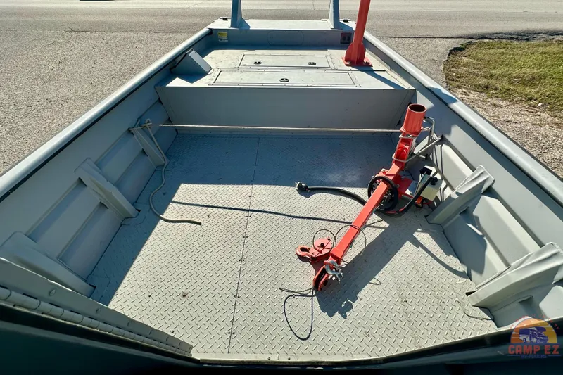 Slide: The Image of 2024 SeaArk 2672 Workhorse boat with cabin, parked outdoors, featuring a spacious deck. - 21