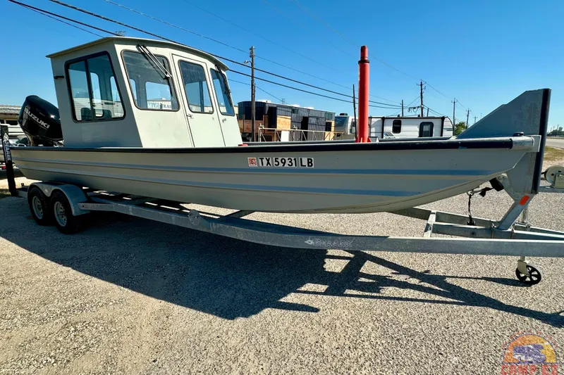 Slide: The Image of 2024 SeaArk 2672 Workhorse boat with Suzuki outboard engine on a trailer. - 3