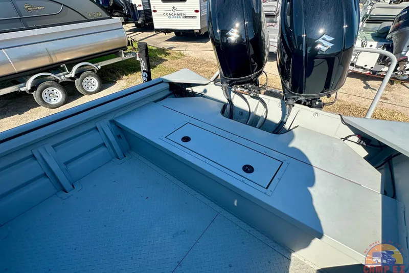 Slide: The Image of 2024 SeaArk 2672 Workhorse boat with dual Suzuki outboard motors, parked outdoors. - 9