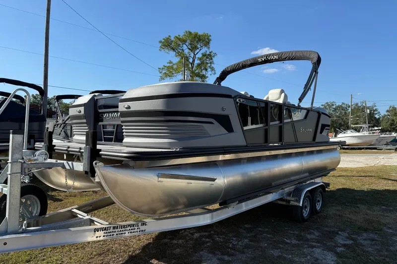 Slide: The Image of 2026 Sylvan R22 pontoon boat on trailer, displayed outdoors under clear sky. - 16
