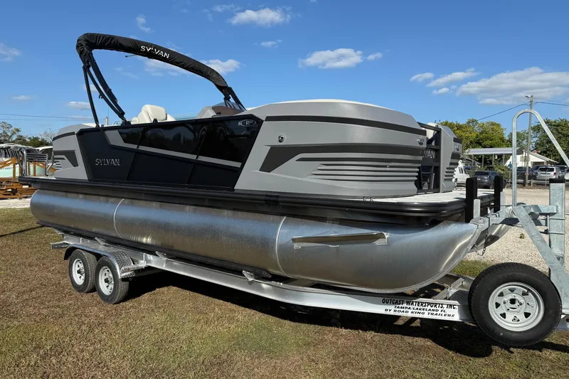 Slide: The Image of 2026 Sylvan R22 pontoon boat on trailer under clear blue sky. - 17