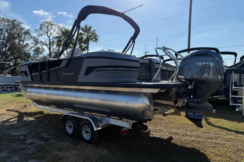 Slide: The Image of 2026 Sylvan R22 pontoon boat on trailer with Yamaha outboard motor, parked outdoors. - 2
