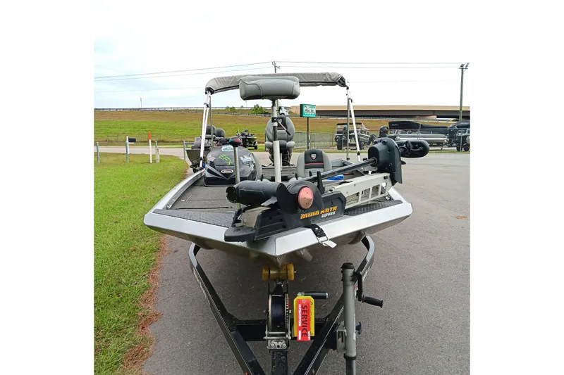 Slide: The Image of 2017 Triton 18 C TX boat on trailer, equipped with Minn Kota motor, parked outdoors. - 4