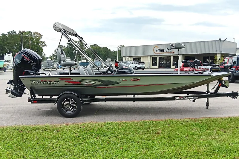 Slide: The Image of 2017 Triton 18 C TX boat with motor on trailer, parked outside dealership. - 6