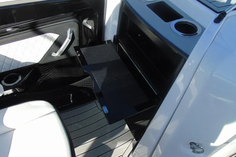Slide: The Image of 2026 Yamaha Boats 252SD interior with storage compartment and cup holders. - 18