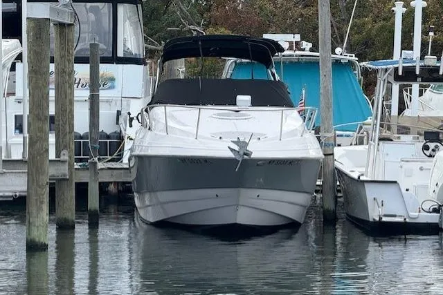 The Image of 2016 Glastron GS 289 boat docked at a marina, surrounded by other vessels. - 1