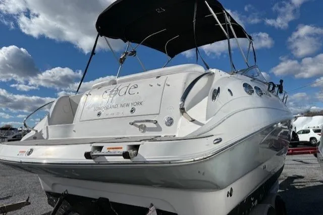Slide: The Image of 2016 Glastron GS 289 boat with canopy, parked on a trailer under a blue sky. - 11