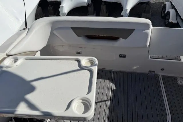Slide: The Image of 2016 Glastron GS 289 boat interior with seating and table, featuring cup holders. - 13