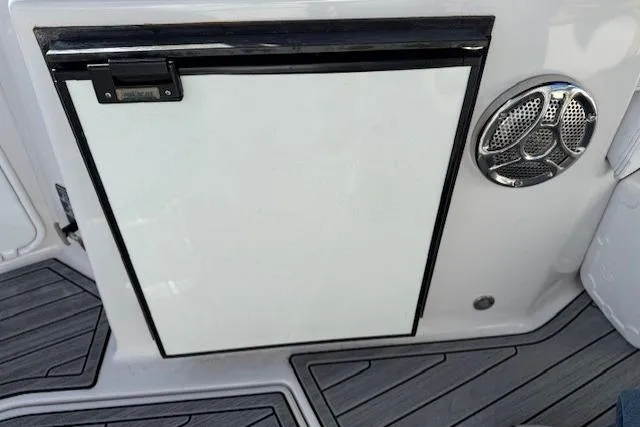 Slide: The Image of 2016 Glastron GS 289 boat interior with a white compartment door and speaker. - 16