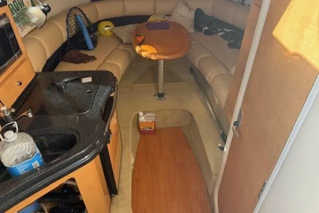 Slide: The Image of 2016 Glastron GS 289 boat interior with kitchenette and seating area. - 20