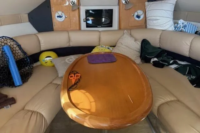 Slide: The Image of Interior of 2016 Glastron GS 289 boat with cozy seating and wooden table. - 21