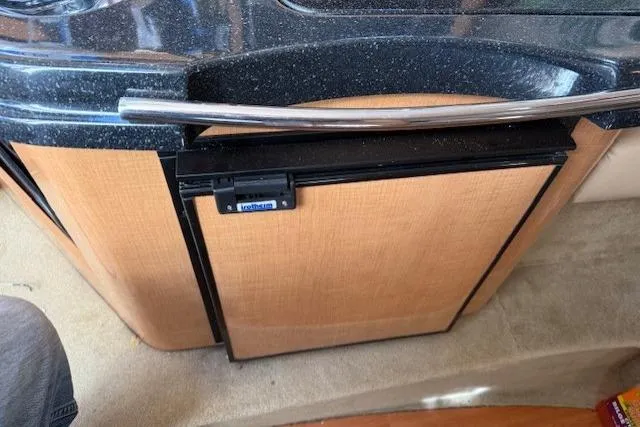 Slide: The Image of 2016 Glastron GS 289 interior with compact refrigerator and sleek countertop design. - 23