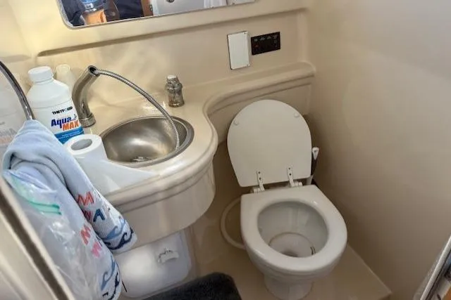Slide: The Image of 2016 Glastron GS 289 boat bathroom with sink, toilet, and toiletries. - 26