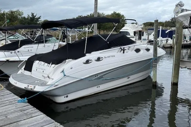 Slide: The Image of 2016 Glastron GS 289 boat docked at marina, featuring sleek design and black canopy. - 3