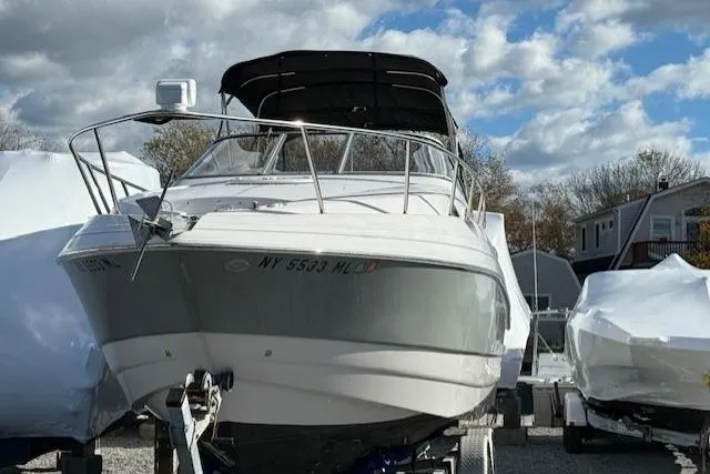 Slide: The Image of 2016 Glastron GS 289 boat on trailer, parked outdoors under a partly cloudy sky. - 6